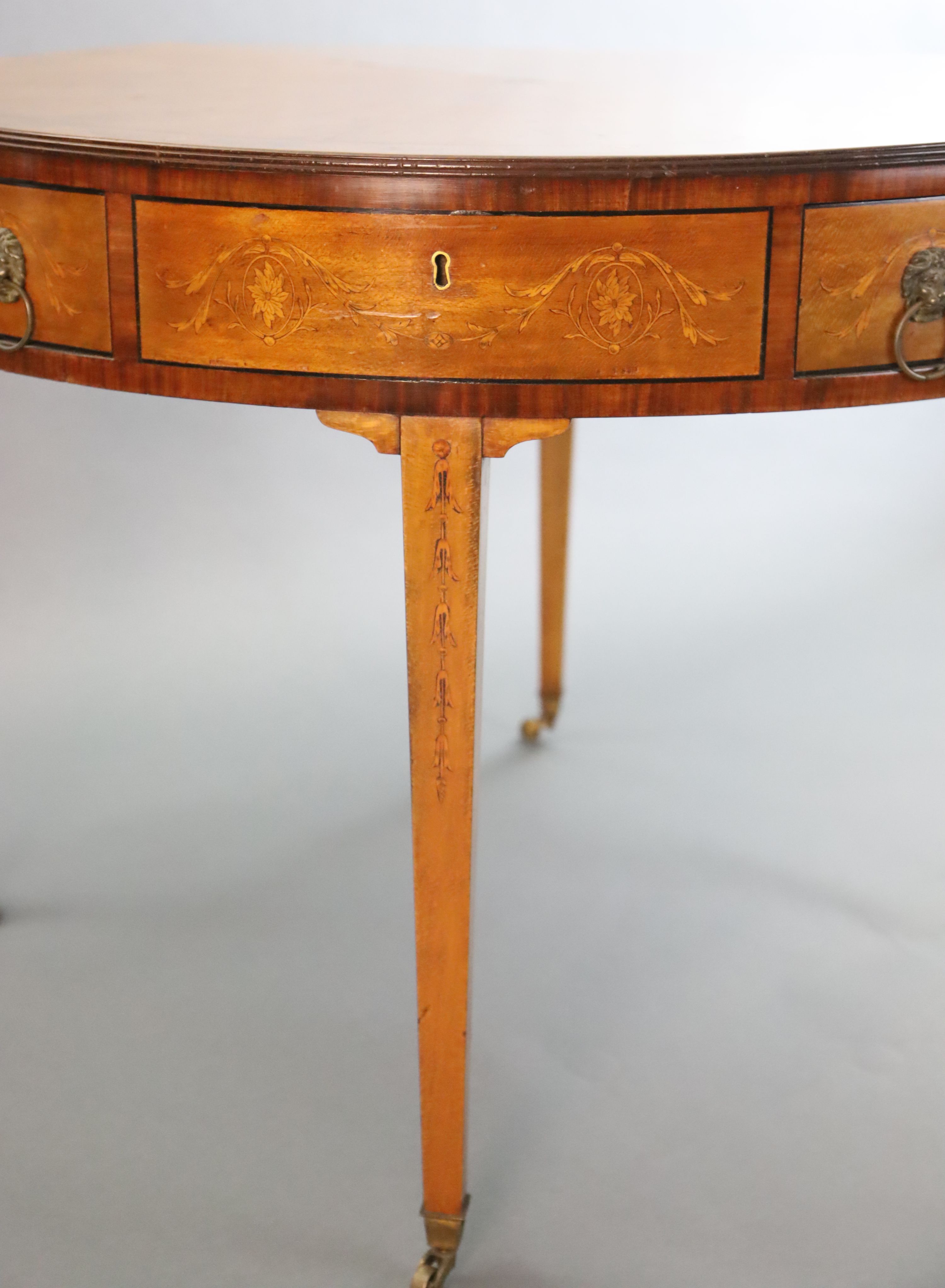 An Edwardian marquetry inlaid satinwood drum top library table, Diam. 3ft 5.5in H.2ft 5.5in.